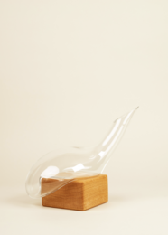 Elegant glass decanter with a wooden stopper, featuring a unique shape and design. Suitable for serving and storing various liquids.