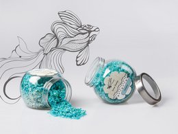 Natural soap flakes with ocean fragrance, packaged in a glass jar with turquoise-colored contents. Includes a bar of natural soap.