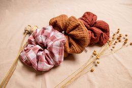 Large checkered pink scrunchie made of soft, textured fabric. Ideal for styling hair and adding a touch of pattern to any look.