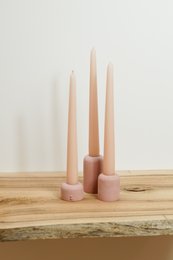 Tall, cylindrical pink candle holders made of a smooth, matte material, suitable for use in a candelabra or as standalone decor.