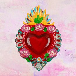 A red heart-shaped napkin holder with colorful floral and decorative elements.
