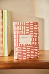  Pink handmade notebook with geometric woven pattern, pocket-sized, artisanal design