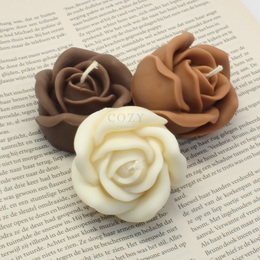 Cream, beige, and pastel rose-shaped pillar candles in various colors including pink, lilac, and yellow.