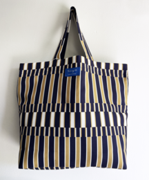 A navy and white striped beach bag with a structured shape and leather handles.