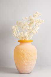 Handcrafted opaque colored glass vase in a warm orange hue with a unique textured surface.