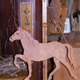 Rustic metal decorative horse sculpture, available as a garden stake or mounted on a base plate. Features a rust-colored finish and simple, abstract horse design.
