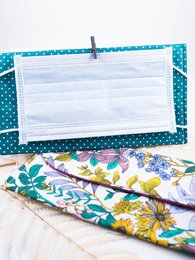 Mask pouch in various floral and patterned designs, including moutarde et fleurs blanches, bleue, bleue marine et fleurs jaunes bleues, blanc bohème, vert bohème, noir et blanc, noir et or, jaune et fleurs bleues, bleue petits points, bordeaux, plumes de paon, and vintage chic.