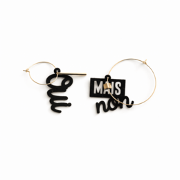 Black and white mismatched hoop earrings with French text "Oui mais non" charms, asymmetrical design, statement jewelry.