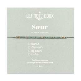 Silver and gold beaded bracelet with "Soeur" (Sister) text on a light gray background with lace.
The product is a beaded bracelet available in silver and gold colors. The bracelet has the text "Soeur" (French for "Sister") printed on it, indicating it is a gift or accessory for a sister. The bracelet is displayed on a light gray background with a lace pattern, giving it a delicate and feminine aesthetic.
