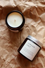 Natural soy wax candle with ginger lily essential oils, round shape, amber glass container.