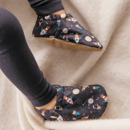 Navy blue baby shoes with a space-themed print, featuring planets, stars, and rockets. The shoes have a soft, plush interior for comfort.