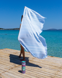 Light blue hammam towel with colorful chevron pattern, made of recycled materials and packaged in a recycled gift box.