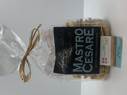 Artisanal cookies in a clear plastic bag, tied with a brown twine bow. The cookies are labeled "Mastro Cesare" in a black and white design.