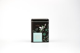 White Night loose tea blend in a black tin container with green leaf design. Contains a variety of tea leaves.