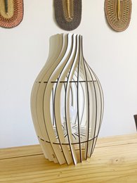 Elegant wooden desk lamp with a dynamic, flowing design. Features a tall, slender shape with intersecting wooden slats that create a unique, sculptural silhouette.
