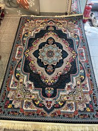 Large dark blue area rug with intricate floral and geometric patterns, suitable for living rooms or bedrooms.