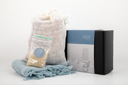 Seaweed foot bath gift package, includes a gray knit throw blanket with fringe and a black box.