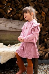A pink, ruffled skirt with a floral pattern, suitable for a young girl. The skirt has an elastic waistband and a flared, layered design.