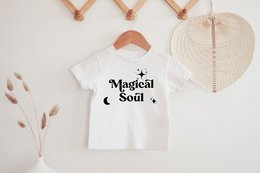White kids t-shirt with "Magical Soul" text and moon graphic. Available in sizes 0-3 months to 12-13 years.