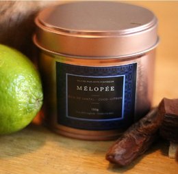 Sandalwood, coconut, and lemon scented candle in a copper-colored tin container.