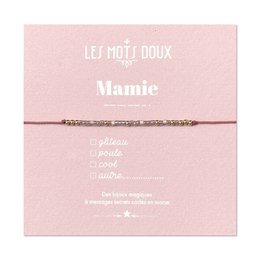  A delicate, pink-colored bracelet with the name "Mamie" written on it. The bracelet appears to be made of beads or threads, with a simple, elegant design.