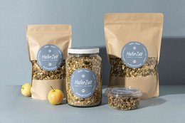 Organic granola with apple and hemp, available in 750g bag, 300g bag, and 750g jar. Made with natural ingredients.
