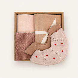  A soft, plush gray elephant-shaped gift box with a pacifier, bib, and blanket. The gift set is designed for babies and young children, featuring neutral colors and natural materials.
