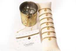 Elegant gold bracelet with customizable letter charm. Features a classic chain design and a circular charm that can be personalized with an initial letter. Suitable for everyday wear or as a thoughtful gift.