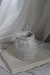 A handmade, matte gray vase with a simple, cylindrical shape.