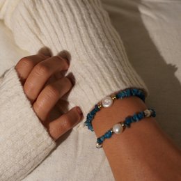 Charm bracelet with apatite stones, pearls, and gold-tone accents. Elegant and versatile accessory.