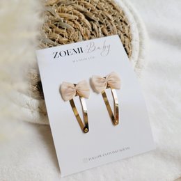 Beige bow-shaped hair clips for kids. Made of high-quality materials, these clips are perfect for adding a touch of style to any hairstyle.
