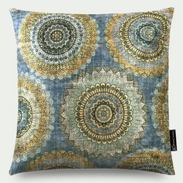 Circular mandala-style patterns in shades of blue, gold, and brown adorn this plush velvet throw pillow. The intricate design and rich colors make this a stylish accent for any living space.