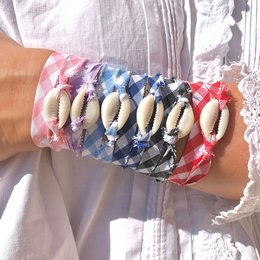Colorful shell and gingham charm bracelet with various shell charms in different colors including blue, yellow, black, orange, pink, red, turquoise, and purple.