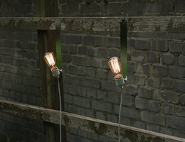 Wall light with two exposed bulbs mounted on a metal frame, suitable for indoor or outdoor use.