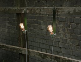 Wall light with two exposed bulbs mounted on a metal frame, suitable for indoor or outdoor use.