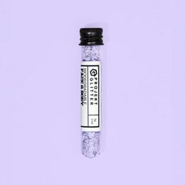 Fine purple eco glitter makeup product with a fluffy, round applicator.