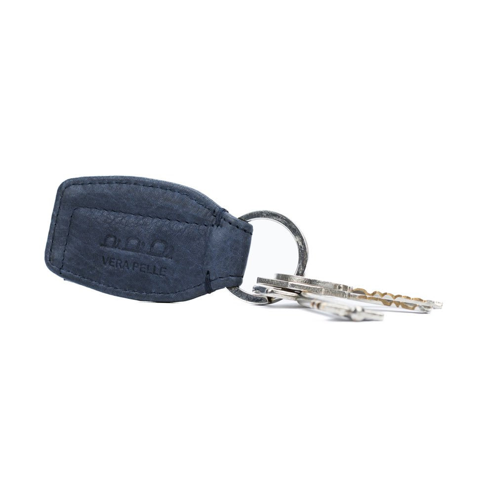 K10753PB | Sleutelhanger van echt volnerf leer, met lichte nerf. Avio-kleur. Ring van gepolijst nikkel. Totale afmetingen: 3,5 x 9 x 0,5 cm. Verpakking: stijve bodem/deksel geschenkdoos