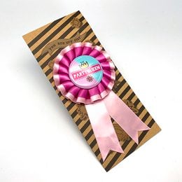 Colorful party buttons with text "Party Queen" in a striped box.