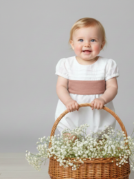 White baby romper with blue waistband, suitable for infants aged 0-18 months.