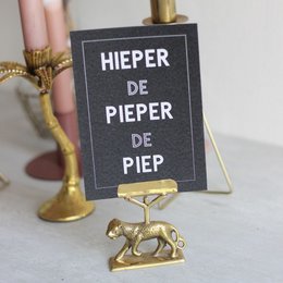 A black card with the text "HIEPER DE PIEPER DE PIEP" in white lettering. The card is displayed on a brown envelope, suggesting it is a birthday card product. The card has a simple, minimalist design with no additional visual elements.