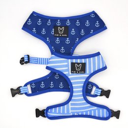 A blue and white striped dog harness with anchor and nautical pattern design, suitable for small to medium sized dogs.