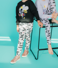 Black sweater with colorful graphic design, white pants with animal print pattern
