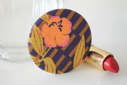 Striped floral pocket mirror with round shape and compact design, suitable for makeup and personal grooming.