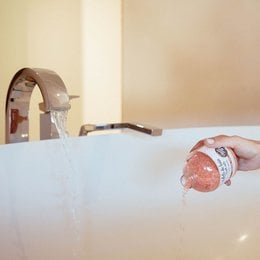 Rose-scented bath salts in a 350g bottle.