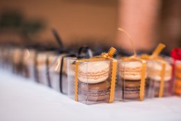 A gift box containing assorted macarons in various pastel colors, arranged neatly on a white surface. The macarons appear to be delicate and visually appealing, making this an ideal gift for chocolate and dessert lovers.