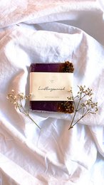 Handmade natural lavender soap with floral accents, rectangular shape, and brown packaging.
